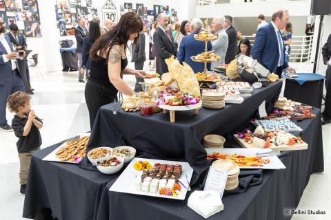 A guest filling their plate with food from the dessert table at the Presidential Farewell Reception at University at Buffalo's Center for the Arts. Photo by Bellini Studios.