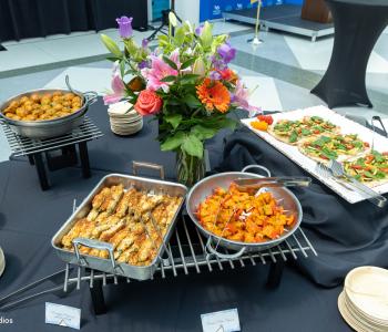 Table of hors d'oeuvres at the Presidential Farewell Reception at University at Buffalo's Center for the Arts, including grilled wrapped asparagus, orange-glazed chicken chorizo meatballs, paneer tikka skewers, and grilled summer vegetable flatbreads. Photo by Bellini Studios.